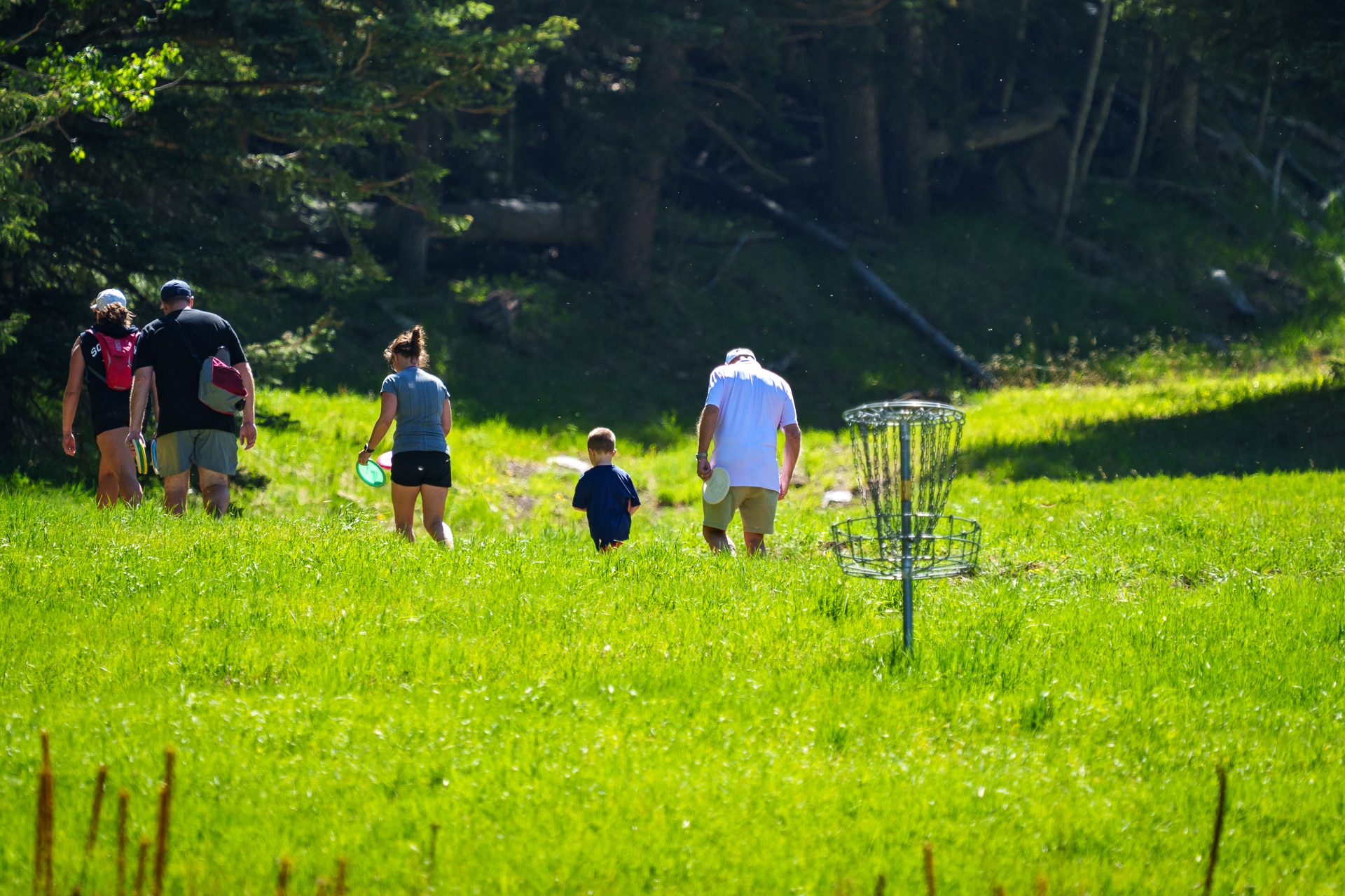 Family walking up disc golf course