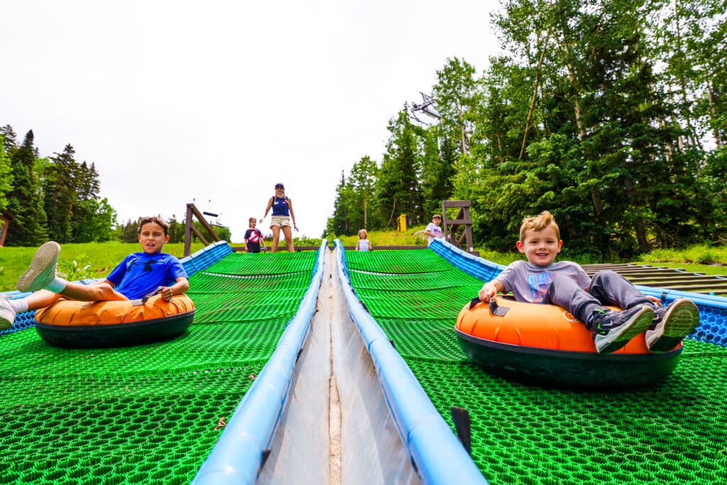 Two boys racing down tubing hill